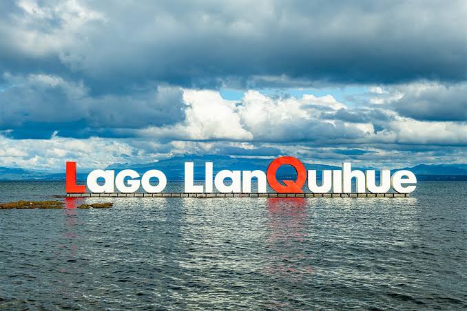 Letras «Lago Llanquihue» instaladas sobre el agua, con el cielo nublado del sur